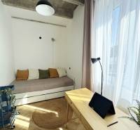 Ein Zimmer in einer 3-Zimmer-Wohnung mit Holzelementen, einem Bett und einem Schreibtisch mit einem Tablet.