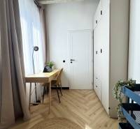 Der Holzboden, der Schreibtisch und der hohe weiße Schrank dominieren in der 3-Zimmer-Wohnung.