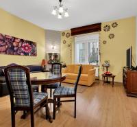 Wohnzimmer mit bequemen Sitzgelegenheiten, Esstisch und Holzboden in einer 3-Zimmer-Wohnung.