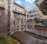 Blick auf den Innenhof von Wohnhäusern mit alter Putzfassade und Balkon.