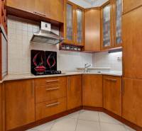 Küche in einer 3-Zimmer-Wohnung mit Holzmöbeln und eingebauten Geräten.