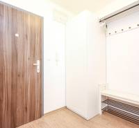 Eingangsflur in einer 2-Zimmer-Wohnung mit Holzboden und Garderobe.