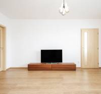 Wohnzimmer in einer 2-Zimmer-Wohnung mit Holzboden und Fernseher.