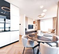 2-Zimmer-Wohnung mit Esstisch, Sofa und Boden in Holzoptik.