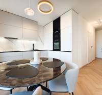 Essbereich mit Marmortisch und Küche in einer 2-Zimmer-Wohnung, Boden mit Holzdekor.