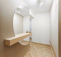 Eingangsbereich mit Holzboden und großem Spiegel in einer 2-Zimmer-Wohnung.