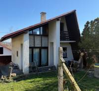 Eine Hütte in Zlaté Moravce mit einem Holzzaun, Rasen und Bäumen in der Umgebung.