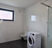 Badezimmer mit Dusche, Waschbecken und Waschmaschine in einer 3-Zimmer-Wohnung.