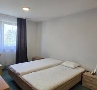 Schlafzimmer mit zwei Betten, Schreibtisch und Fenster in einer 3-Zimmer-Wohnung.