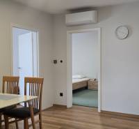 Esstisch mit Stühlen und Boden mit Holzdekor in einer 3-Zimmer-Wohnung.