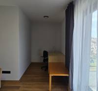 Izba v 3-izbovom byte s podlahou s dreveným dekorom, stolom a pohovkou.