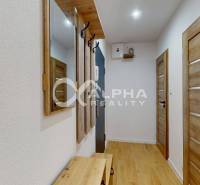 Eingangsflur in einer Einzimmerwohnung mit weißen Wänden und einem Boden in Holzoptik.