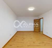 Ein leerer Raum in einer Einzimmerwohnung mit Holzboden und weißen Wänden.