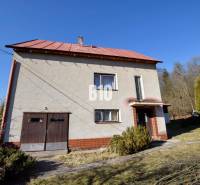 Ein Einfamilienhaus in Raková mit Garage, umgeben von Garten und Bäumen.