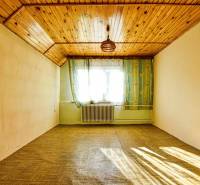 Ein Zimmer in einem Einfamilienhaus mit einer Holzdecke und einem Boden in Holzoptik.