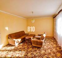 Wohnzimmer mit braunen Sitzmöbeln und Teppich in einem Einfamilienhaus.