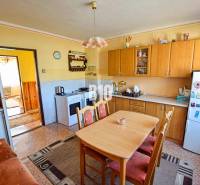 Küche in einem Einfamilienhaus mit Holzschränken und Esstisch.