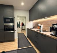 Küche in einer 4-Zimmer-Wohnung mit dunklen Schränken und einem Holzboden.