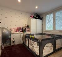 Kinderzimmer in einer 4-Zimmer-Wohnung mit einem Spielgitter und weißen Möbeln.