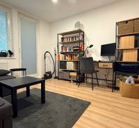 Wohnzimmer in einer 4-Zimmer-Wohnung mit Holzboden und Arbeitsecke.