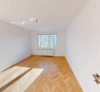 Helles Zimmer in einer 2-Zimmer-Wohnung mit Holzboden und großen Fenstern.