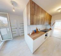 Küche in einer 2-Zimmer-Wohnung mit hellem Boden und Schränken in Holzoptik.
