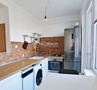 Küche in einer 3-Zimmer-Wohnung mit Holzboden und Geräten.