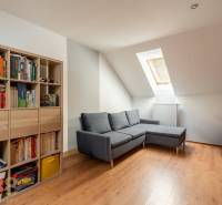 Wohnzimmer mit Ecksofa, Bücherregal und Holzboden in einem Einfamilienhaus.