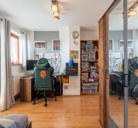 Heimbüro mit Gaming-Stuhl, Desktop-Computer und Schrank, Boden mit Holzdekor.