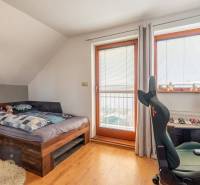 Ein Zimmer mit Bett, Schreibtisch und Stuhl; Boden mit Holzdekor.