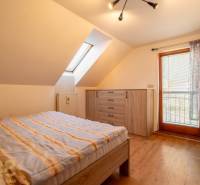 Schlafzimmer mit Holzboden und Dachfenster in einem Einfamilienhaus.