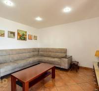 Wohnzimmer in einem Einfamilienhaus mit Ecksofa und Keramikboden.