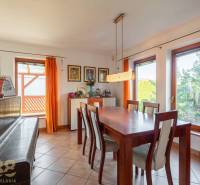 Esszimmer mit großem Tisch, Stühlen und Klavier.