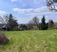 Grünflächen auf Grundstücken - Wohnen in Marianka in der Budovateľská Straße, umgeben von Bäumen und nahegelegenen Häusern.