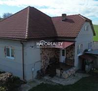 Ein Einfamilienhaus in Rimavské Janovce mit rotem Dach und ländlicher Umgebung.