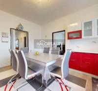 Esszimmer mit roter Küchenzeile und Holzboden in einem Einfamilienhaus.