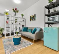 Ein stilvoller Wohnbereich in einer Einzimmerwohnung mit Holzboden, Dekorationen und Pflanzen.