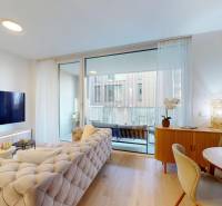 Wohnzimmer in einer Einzimmerwohnung mit Holzboden und Balkon.