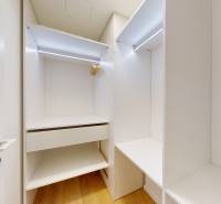 Einbauschrank mit hellem Innenraum und Boden in Holzdekor in einer Einzimmerwohnung.