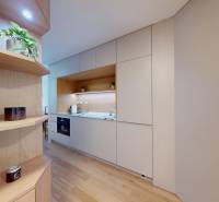 Küche in einer Einzimmerwohnung mit weißen Schränken und Holzelementen.