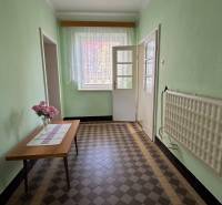 Ein Flur in einem Einfamilienhaus mit Blumen auf dem Tisch und einem gefliesten Boden.