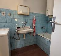 Ein Badezimmer in einem Einfamilienhaus mit blauen Fliesen und einer Badewanne.