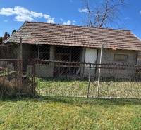Ein Einfamilienhaus in der Hauptstraße in Radava mit einem einfachen Zaun und Rasen.