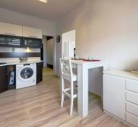 Küche in einer 3-Zimmer-Wohnung mit Esstisch und Boden in Holzoptik.