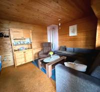 Das Innere der Hütte mit Holzelementen, bequemen Sofas und einer Vitrine für Geschirr.