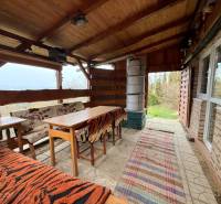 Eine Hütte in Žilina mit Holzmöbeln, Kamin und Blick auf die Natur.