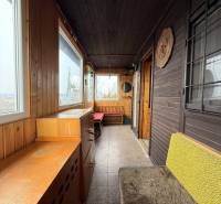 Eine Hütte mit Holzelementen, gemütlichen Möbeln und großen Fenstern mit Blick auf die Natur.