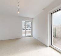 Ein geräumiges Zimmer in einem Einfamilienhaus mit Fenstern und Betonboden, helle Wände.