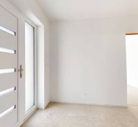 Eingangstür mit Verglasung im Inneren eines Einfamilienhauses mit weißen Wänden.