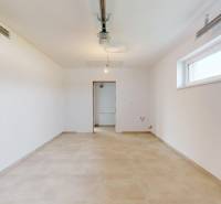 Ein geräumiges Zimmer mit hellen Wänden und einem Fenster in einem Einfamilienhaus, Boden mit Dekor.